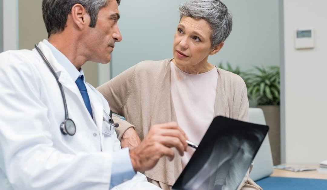 medico fa vedere lastre di ossa a donna con osteoporosi