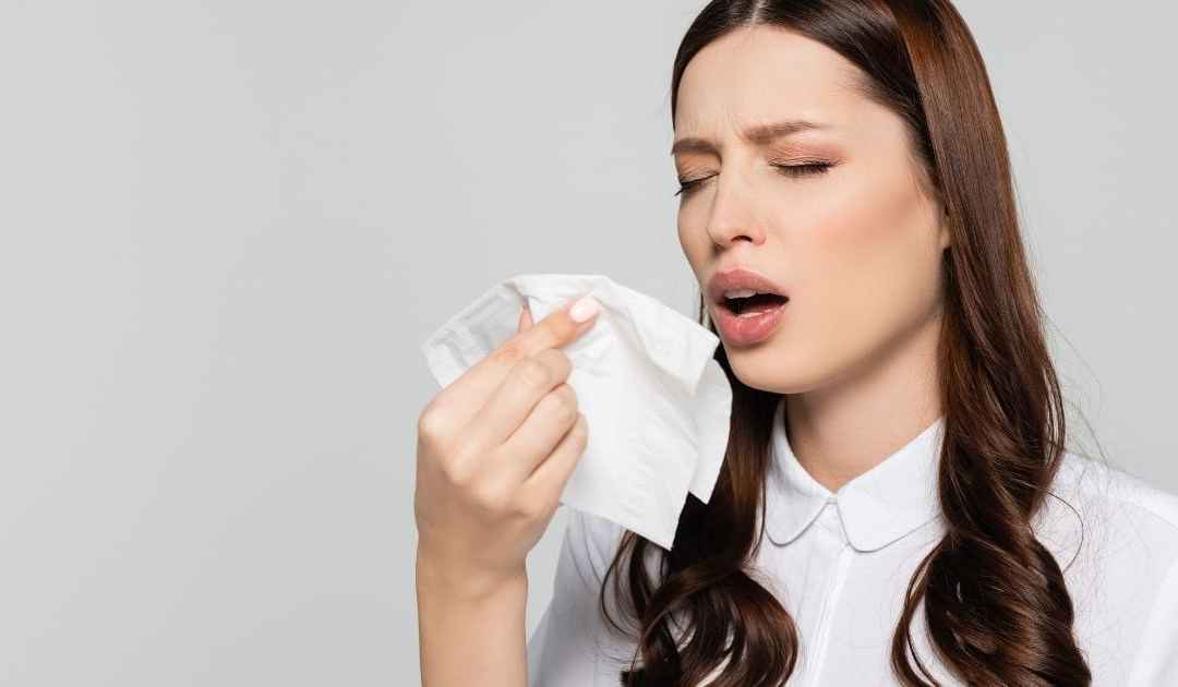 donna starnutisce - come guarire dal raffreddore in estate