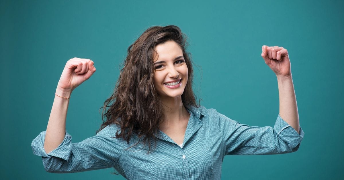 ragazza giovane con braccia alzate in segno di forza e vitalità