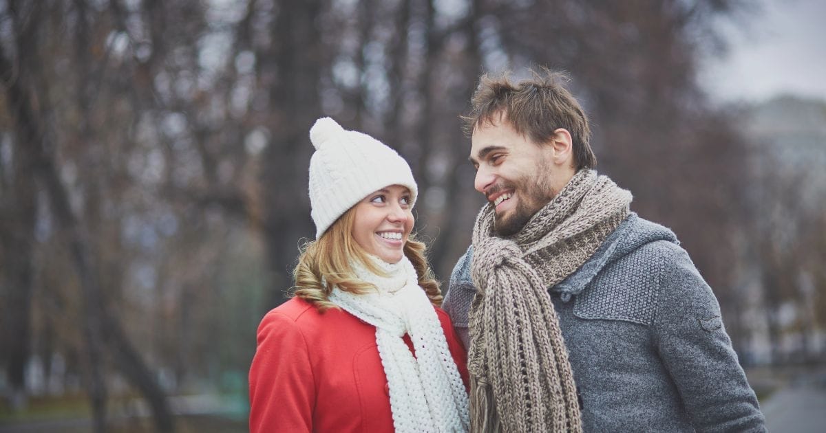 uomo e donna felici in un prato in inverno